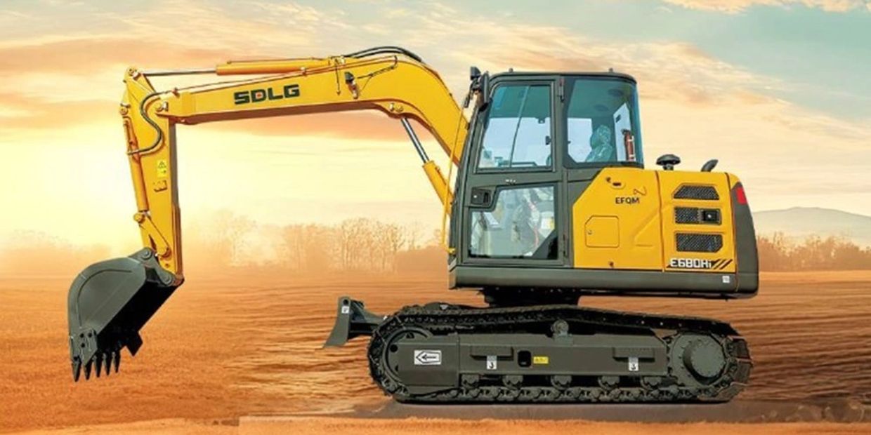 Yellow SDLG excavator on a construction site at sunset.
