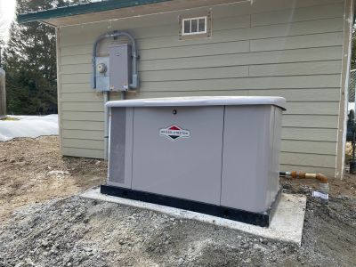 A standby generator installed outside a house on a concrete slab.