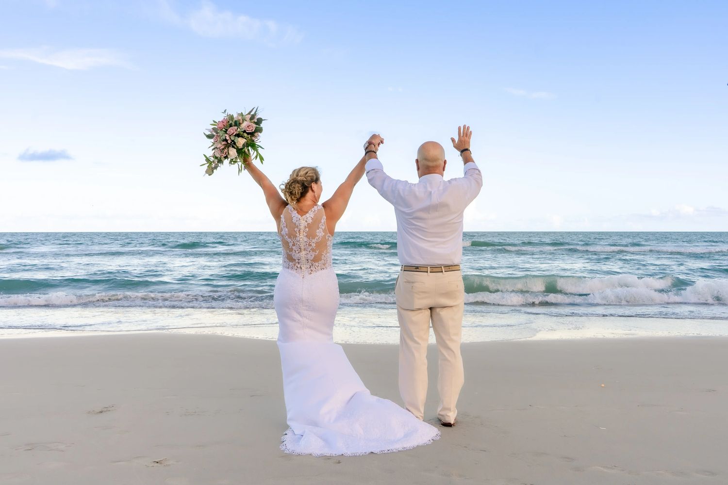 Couple celebrating on the beach after their wedding