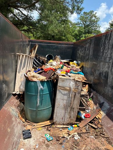 Dumpster filled with assorted debris and waste.