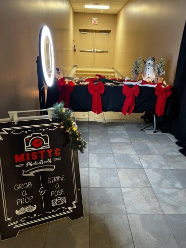 Festive photo booth setup with props and decorations in a hallway.