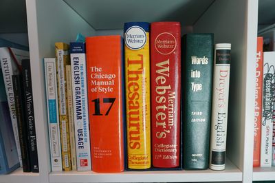 A shelf filled with books on writing, grammar, and style guides.