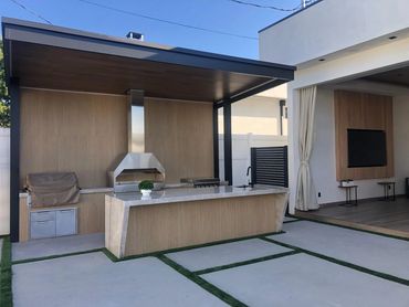 Backyard, outdoor kitchen with counter are for sitting and dining and a traditional charcoal barbecu