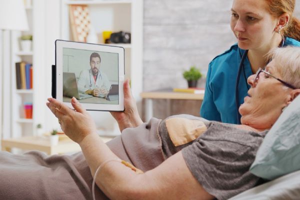 Elderly woman having a telemedicine consultation with a doctor via tablet.