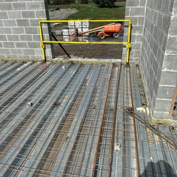 Construction site with steel rebar and concrete blocks in progress.