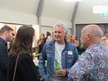 People engaged in conversation at a social gathering indoors.