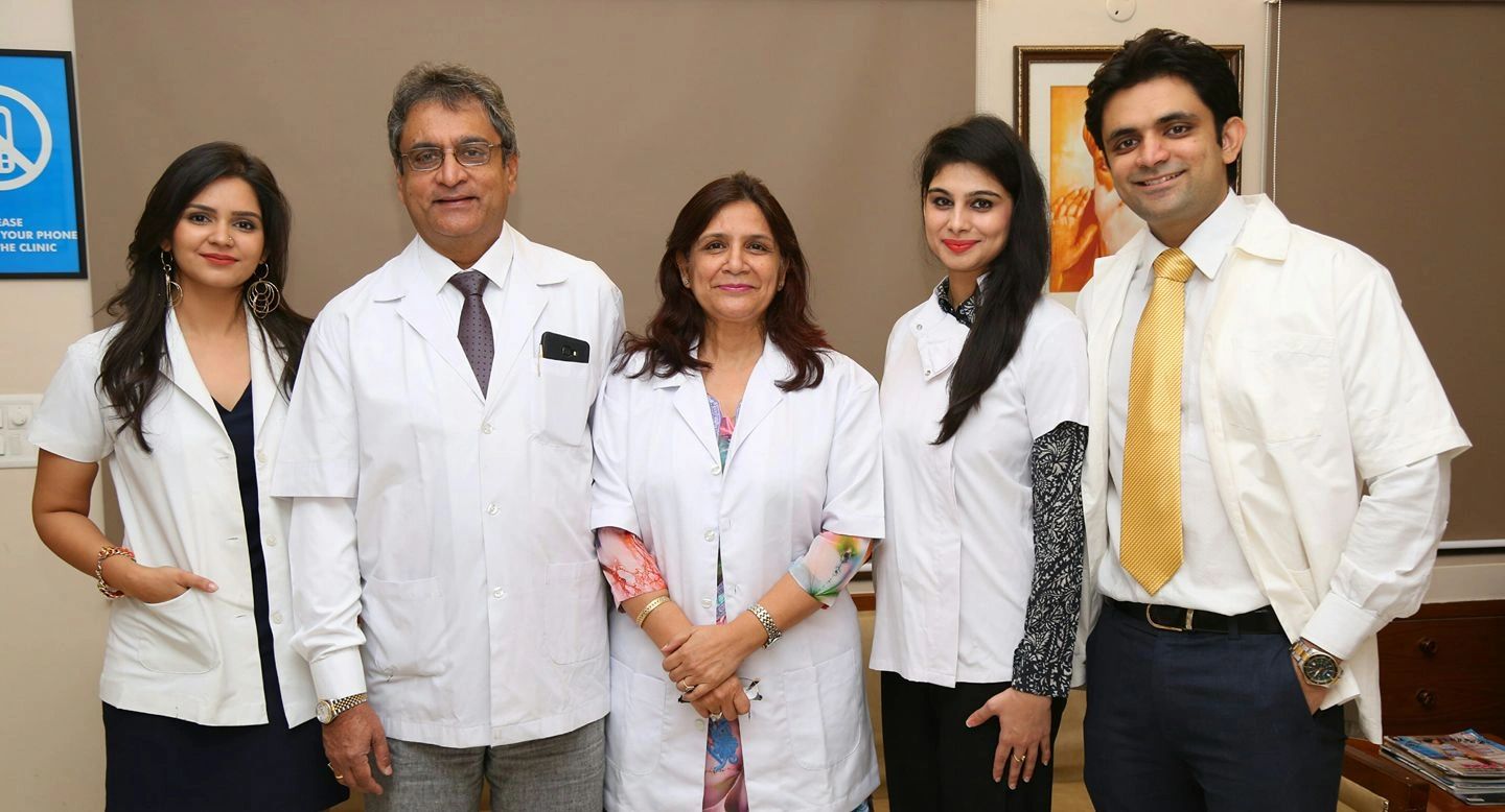 Group of five medical professionals posing in white coats.