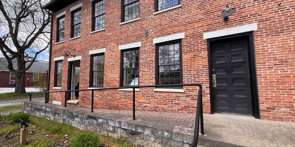 Red brick building with black doors and windows.