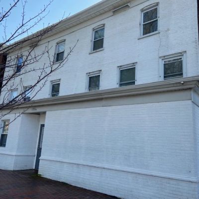 White brick building with closed windows.