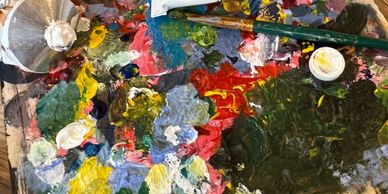 A colorful artist's palette with mixed paints and brushes.