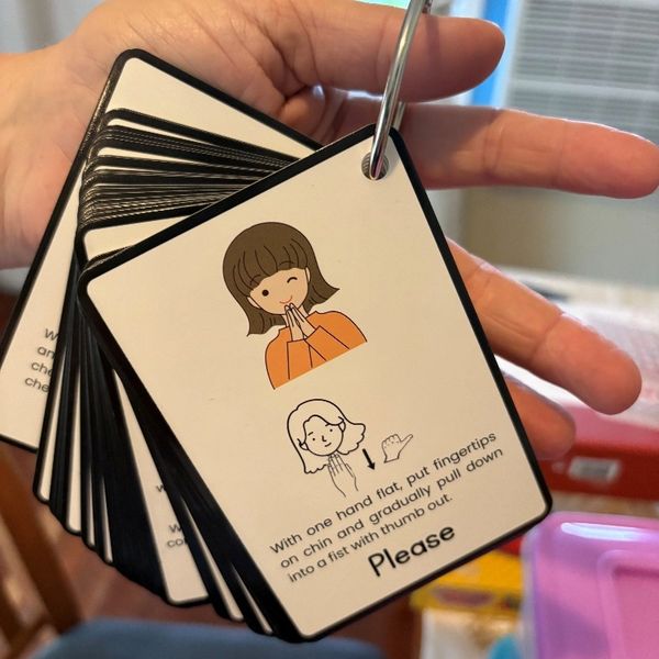 Hand-held cards showing polite gesture instructions with illustrations.
