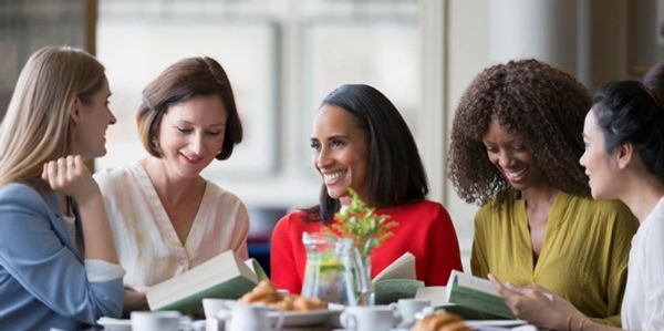 Women talking holding books