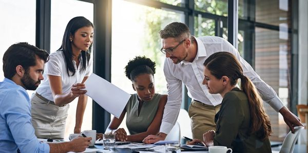 Five people looking at some papers during a meeting