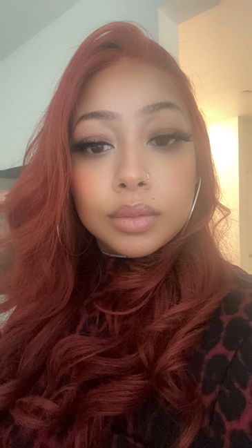 Hunny D, cook and owner of LemmeFeedYouSumn, selfie with red hair and glam makeup