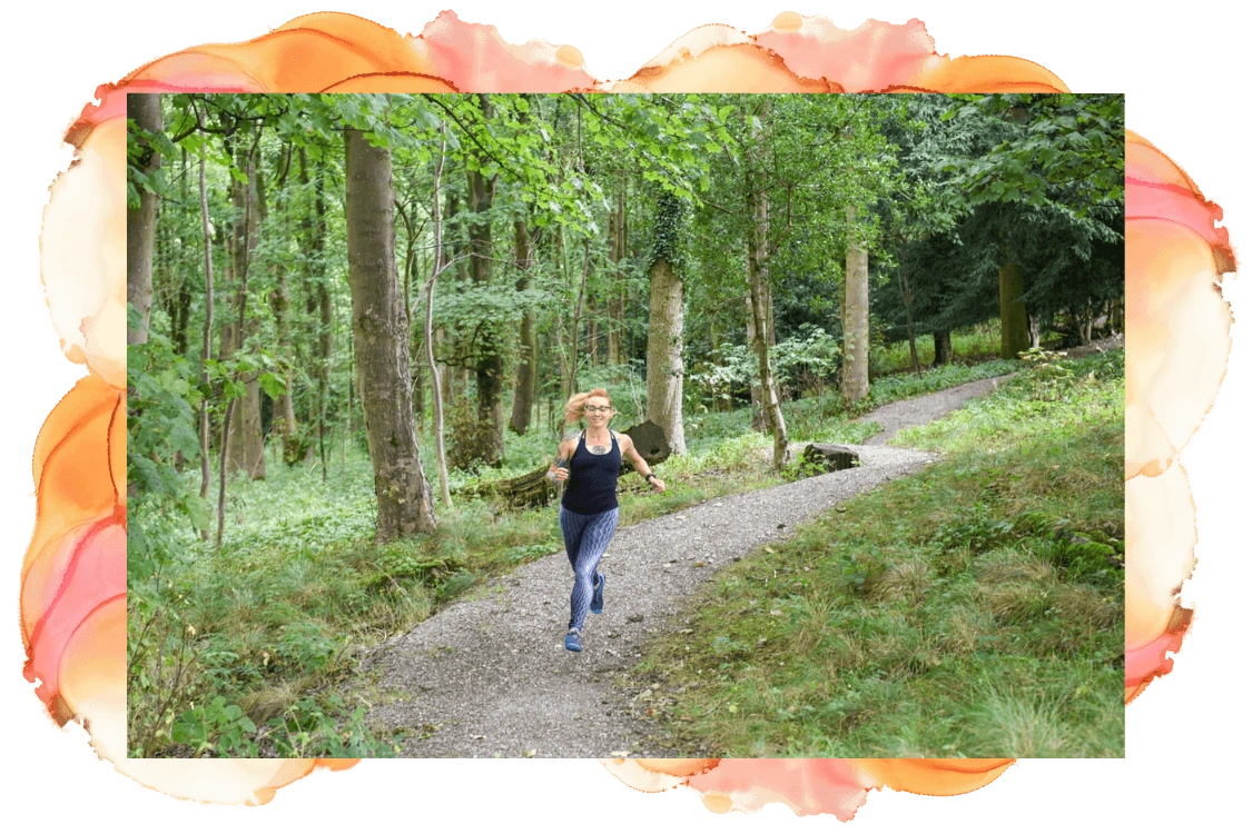 Linda running along a trail through a woodland area