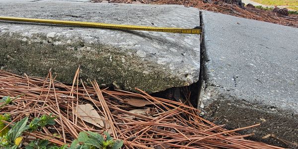 Tape measure showing gap between two concrete slabs.