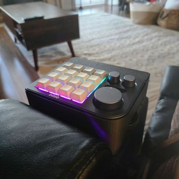 Close-up of a compact mechanical keyboard with RGB lighting and control knobs.