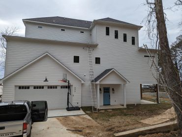 Modern white two-story house with a garage and blue front door.