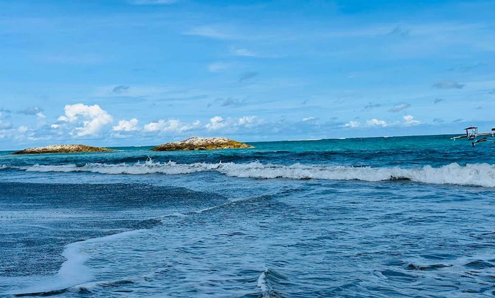 Serene ocean waves gently hitting the shore under a clear blue sky.