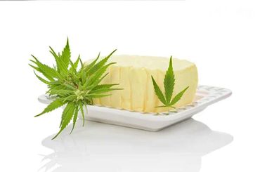 A block of butter with cannabis leaves on a plate.