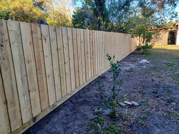 Stacked or board-on-board style wood fence with rot board.