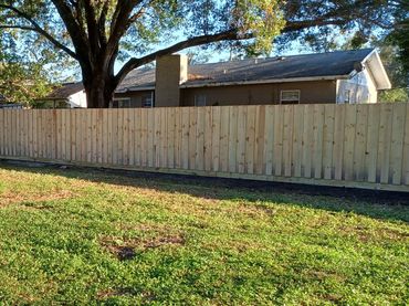 Stacked or board-on-board style wood fence with rot board.