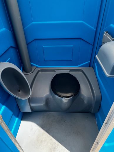 Interior of a portable blue porta-potty with a black seat.