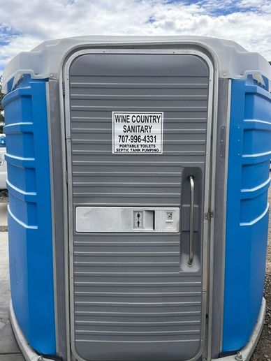 Blue portable toilet with sign for Wine Country Sanitary.