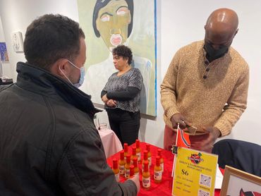 Jamal Thomas selling a bottle of Shirley's Scarborough Spice at Deana ETC. Pop up shop event.