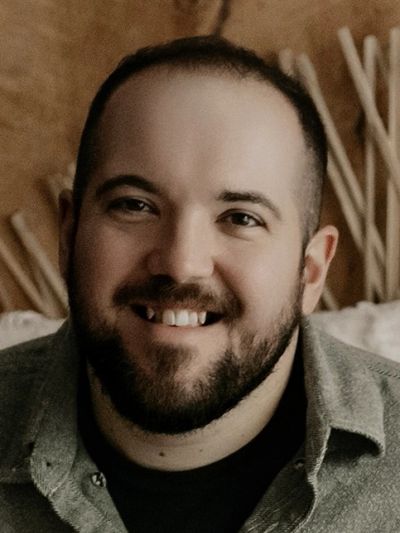 Smiling man with beard and short hair.