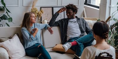A couple in an active therapy session discussing a topic with a therapist