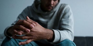 Male sitting down with hands crossed
