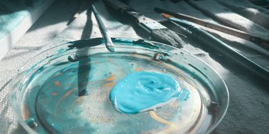 Paint on a plate and a pile of brushes