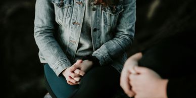 A women in a jean jacket talking with another person next to her