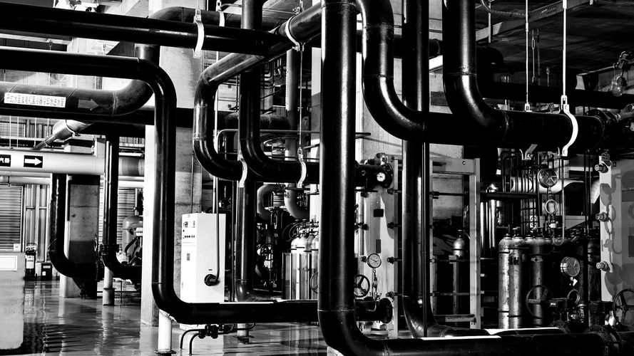 Industrial pipes and machinery in a factory setting.