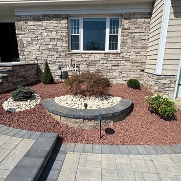 Neatly landscaped front yard with stone accents and small bushes.