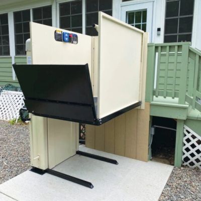 A vertical platform lift attached to the exterior of a house