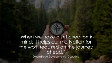 Hand holding a compass in a forest with a quote about setting our own direction.