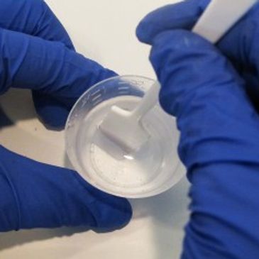 This picture shows the delicate process of mixing resin in the right ratio to achieve a proper cure