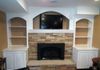 Fireplace after remodel with stone and custom built in shelves and cabinets