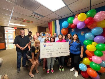 Group of people presenting a $5000 donation check to Young Elementary school.