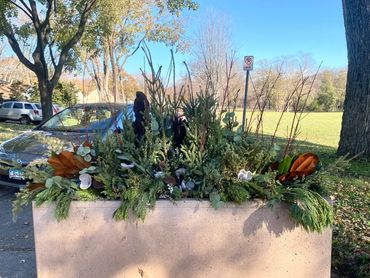 Community planters decorated berries, magnolia, spruce tops, juniper, eucalyptus, and lotus.