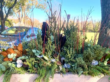 Community planters decorated berries, magnolia, spruce tops, juniper, eucalyptus, and lotus.