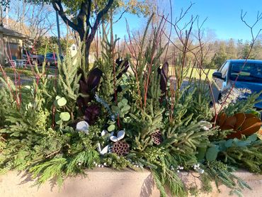 Community planters decorated berries, magnolia, spruce tops, juniper, eucalyptus, and lotus.