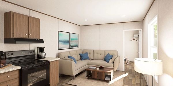 Cozy living room with beige sectional sofa and kitchen area.