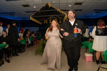 A couple walks arm-in-arm at a formal event.