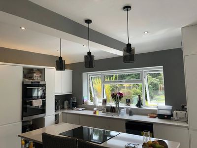 A beautiful kitchen with an island and pendant lighting. Electrics fitted my Simax Electrical.