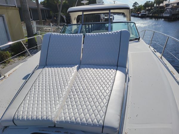 Quilted white leather seating on a yacht deck under bright sunlight.