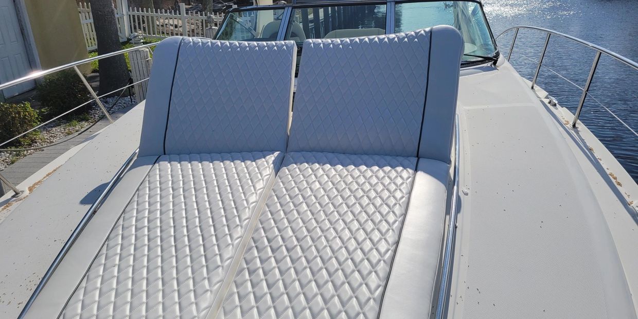 White quilted seats on a boat deck under bright sunlight.
