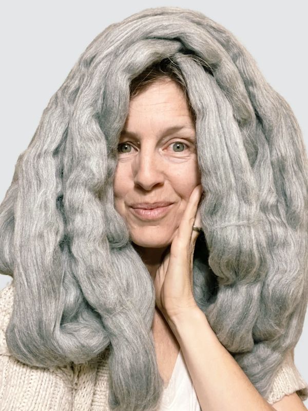 Woman with grey roving wool on her head